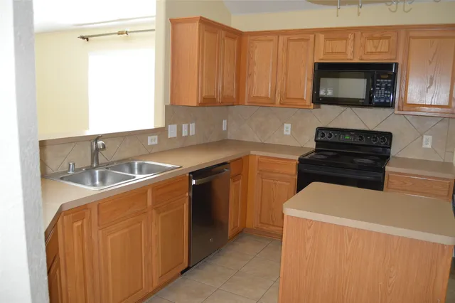 a kitchen with granite countertop a stove a sink and a microwave