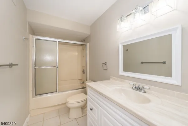 a bathroom with a granite countertop sink a toilet and shower