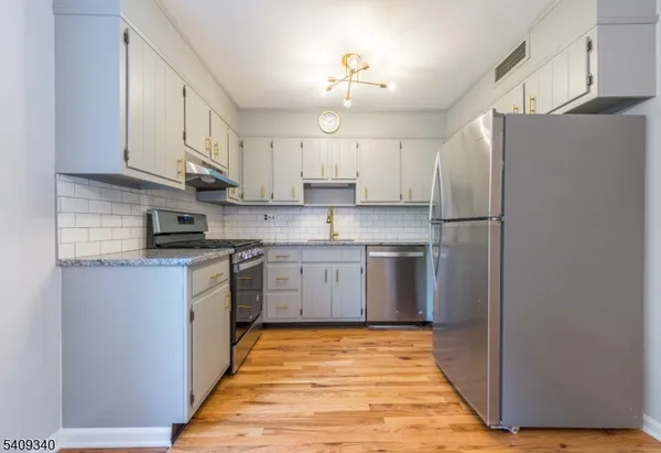 a kitchen with a refrigerator sink and cabinets