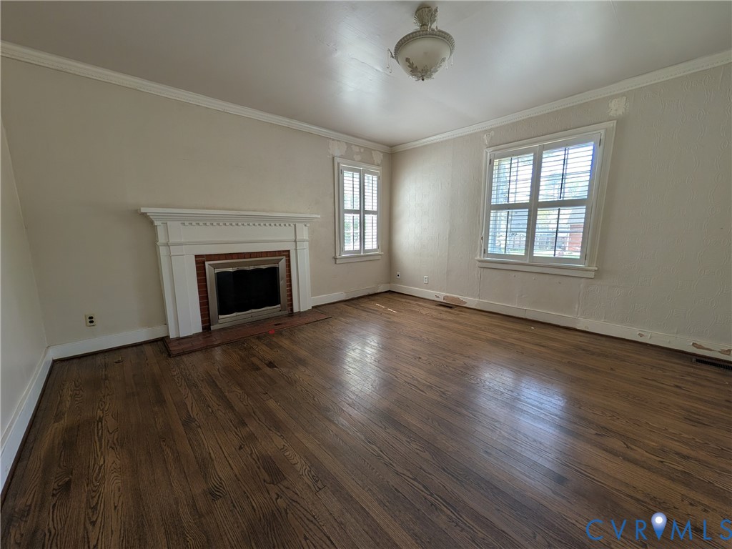 12307 Buckingham Street Chester, VA 23831 - Photo 11 of 40 an empty room with wooden floor fireplace and windows