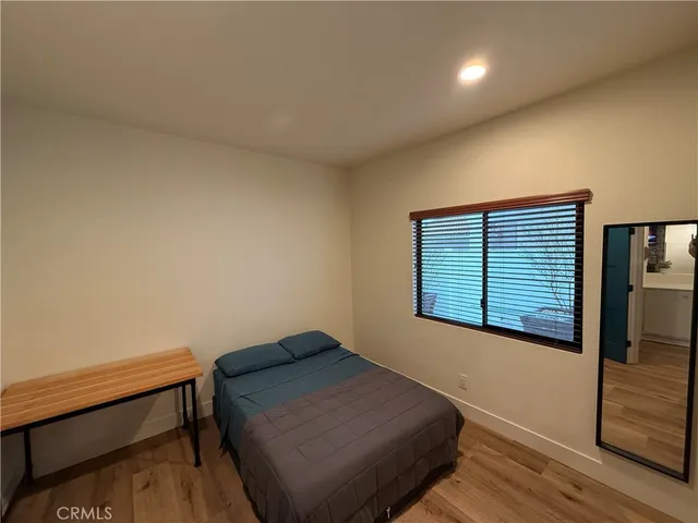 a bedroom with a bed and wooden floor