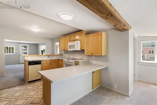 a view of a kitchen with wooden floor and a window