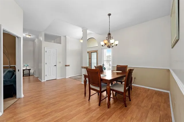 a view of a dining room with furniture a chandelier and wooden floor