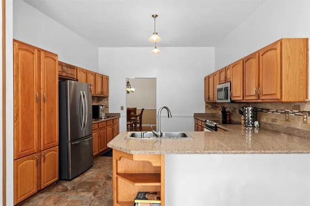 a kitchen with stainless steel appliances granite countertop a refrigerator and a sink