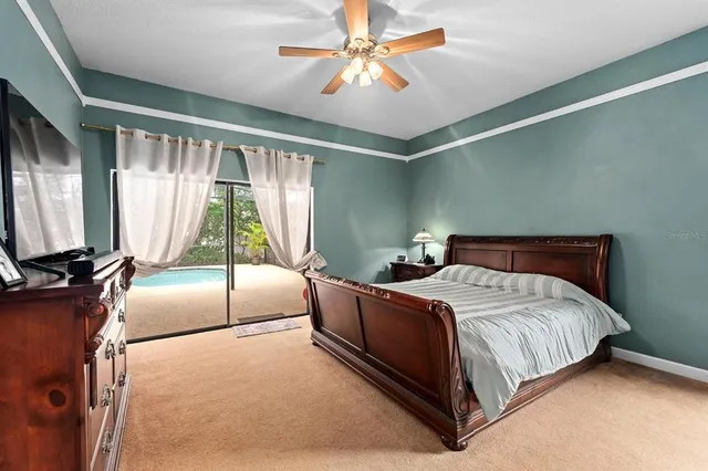 a bedroom with a large bed and a chandelier
