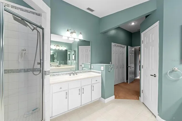 a bathroom with a double vanity sink toilet mirror and shower