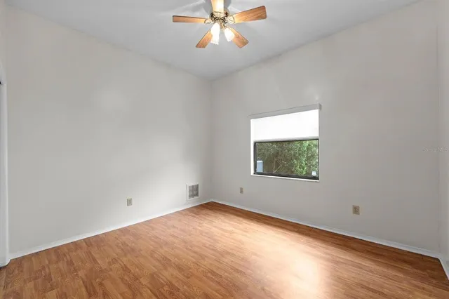 an empty room with a window and a ceiling fan