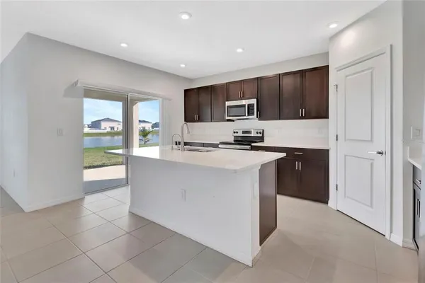 a kitchen with kitchen island white cabinets and refrigerator