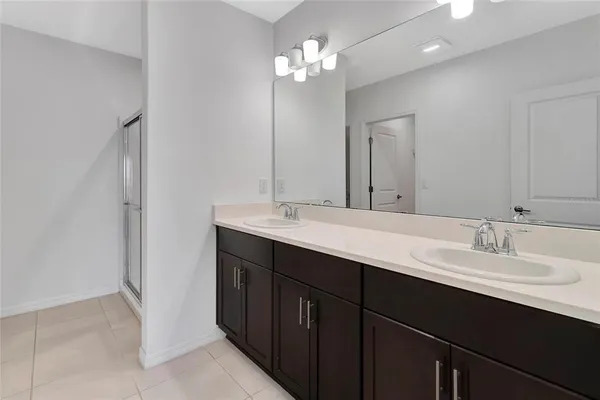a bathroom with a double vanity sink and a mirror