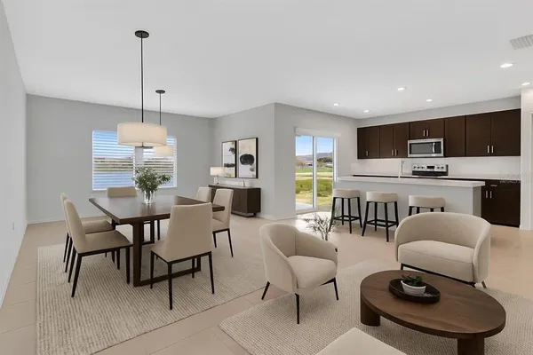 a living room with furniture a rug and kitchen view