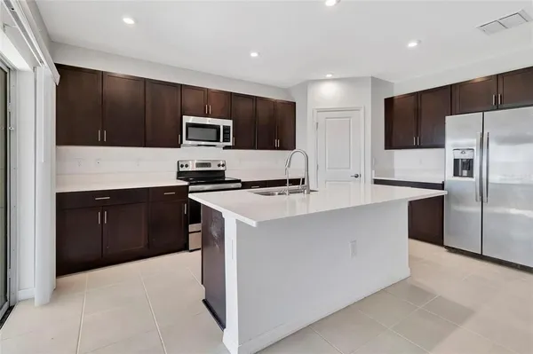 a kitchen with stainless steel appliances a microwave a sink and a refrigerator