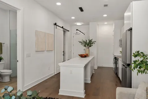 a kitchen with a sink a refrigerator and white cabinets