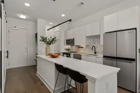 a kitchen with stainless steel appliances a sink and a refrigerator