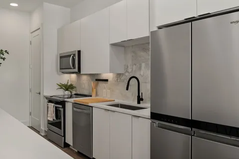 a kitchen with stainless steel appliances a sink a stove a microwave and cabinets
