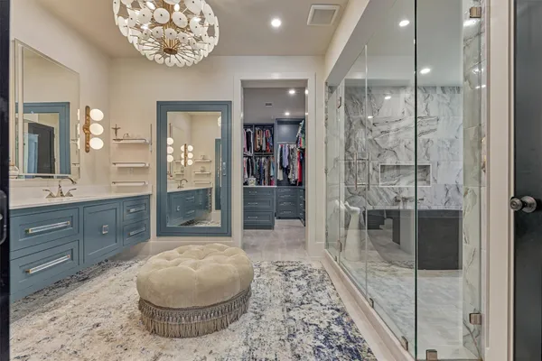 a spacious bathroom with a sink a toilet a glass door a shower and a mirror