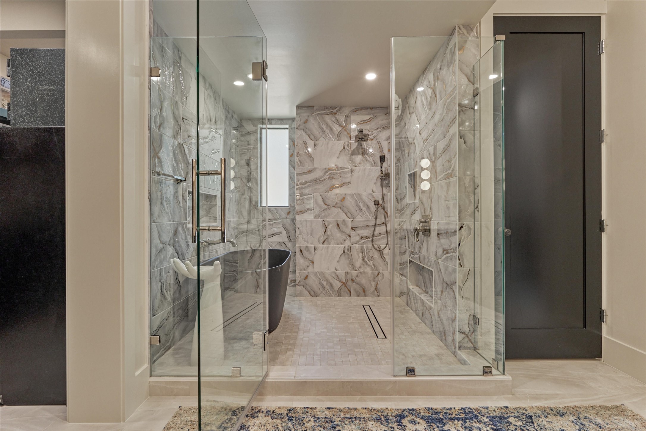 15 Atrium Woods Court The Woodlands, TX 77381 - Photo 22 of 50 a bathroom with a glass shower door