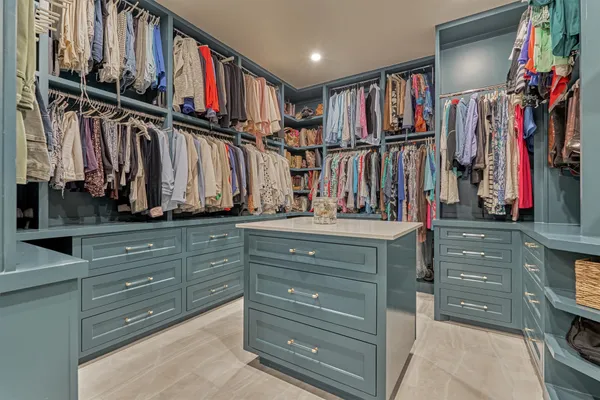 a view of walk in closet with clothes and shoes