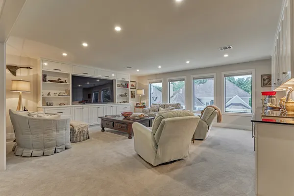 a living room with couches and kitchen view with wooden floor