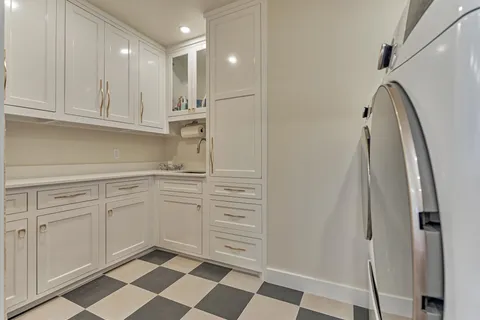 a kitchen with white cabinets and sink