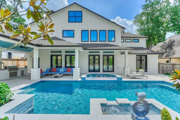 a front view of a house with swimming pool and furniture
