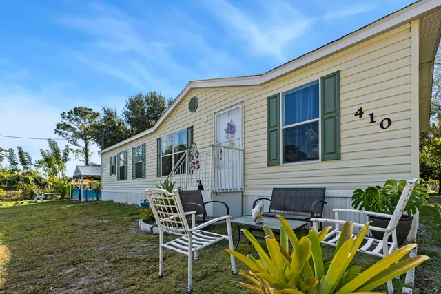 a view of a house with backyard and sitting area