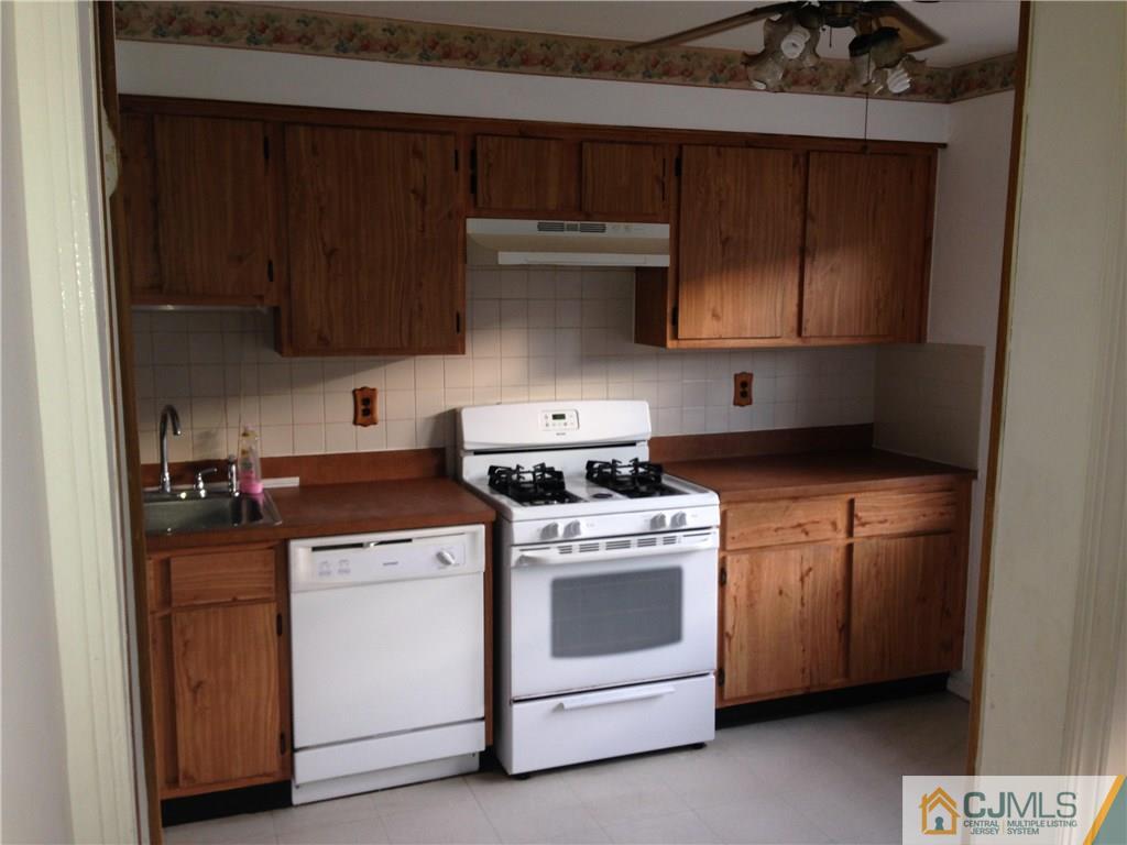 1920 Raspberry Court, Unit 1920 Edison, NJ 08817 - Photo 3 of 12 a kitchen with a stove top oven sink and cabinets