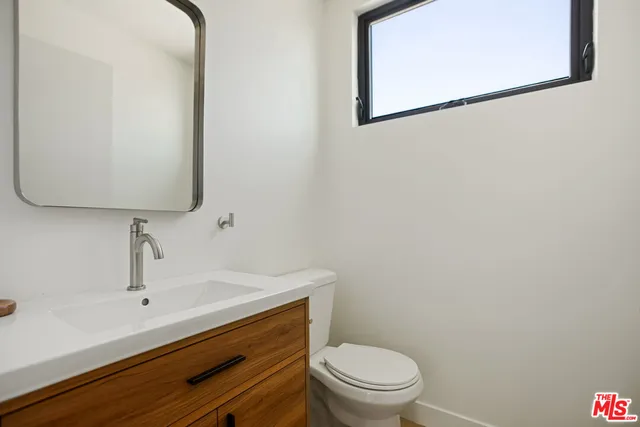 a bathroom with a toilet a sink and mirror
