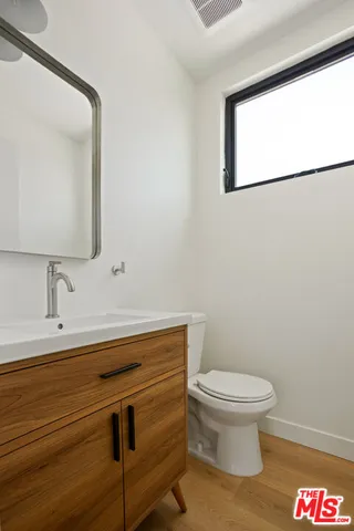 a bathroom with a toilet a sink and mirror
