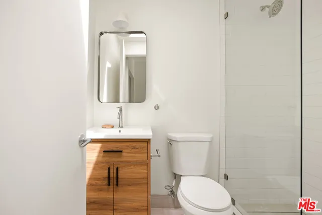a bathroom with a toilet sink vanity and mirror