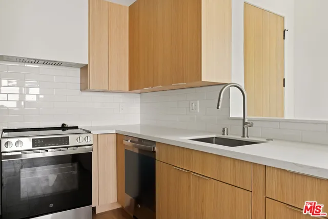 a kitchen with stainless steel appliances granite countertop a sink a stove and oven