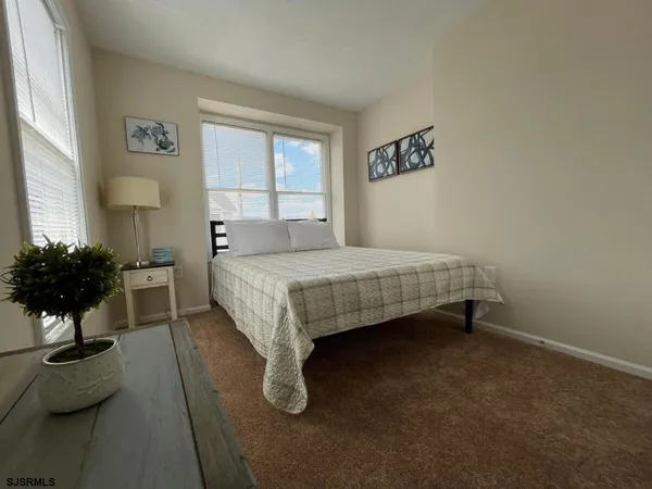 a bedroom with a bed potted plant with the window