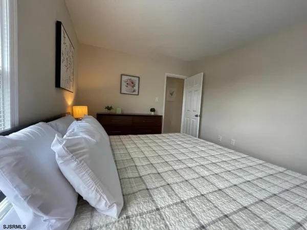 a bedroom with a bed and a lamp on dresser
