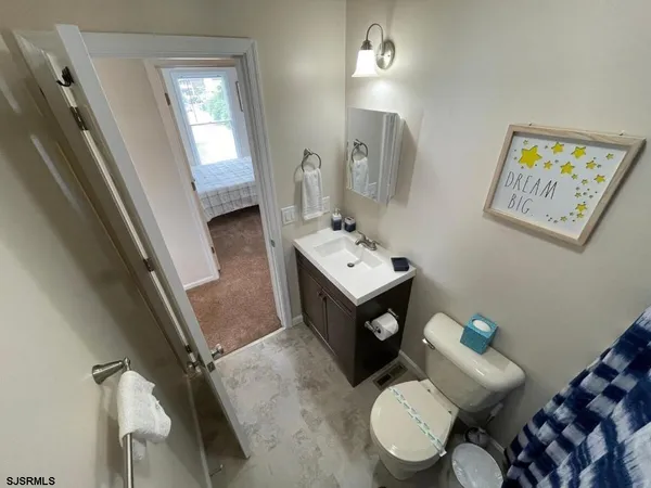 a bathroom with a sink mirror and toilet