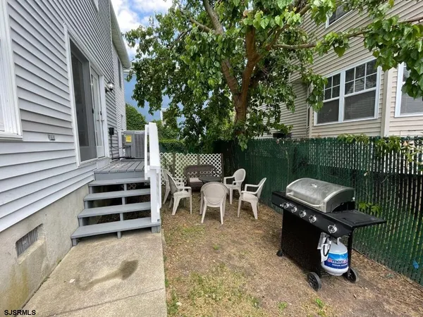 a view of a chairs and table in the back yard of the house