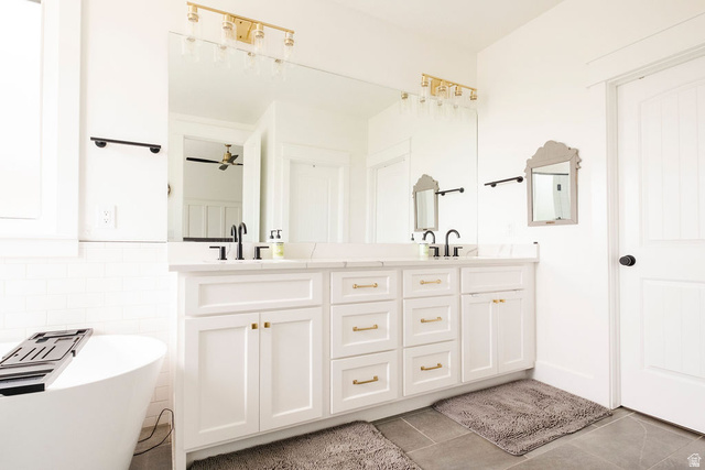 924 Country Lane Farmington, UT 84025 - Photo 32 of 91 Dual vanity with white cabinetry, gold-finish hardware, and a stone countertop