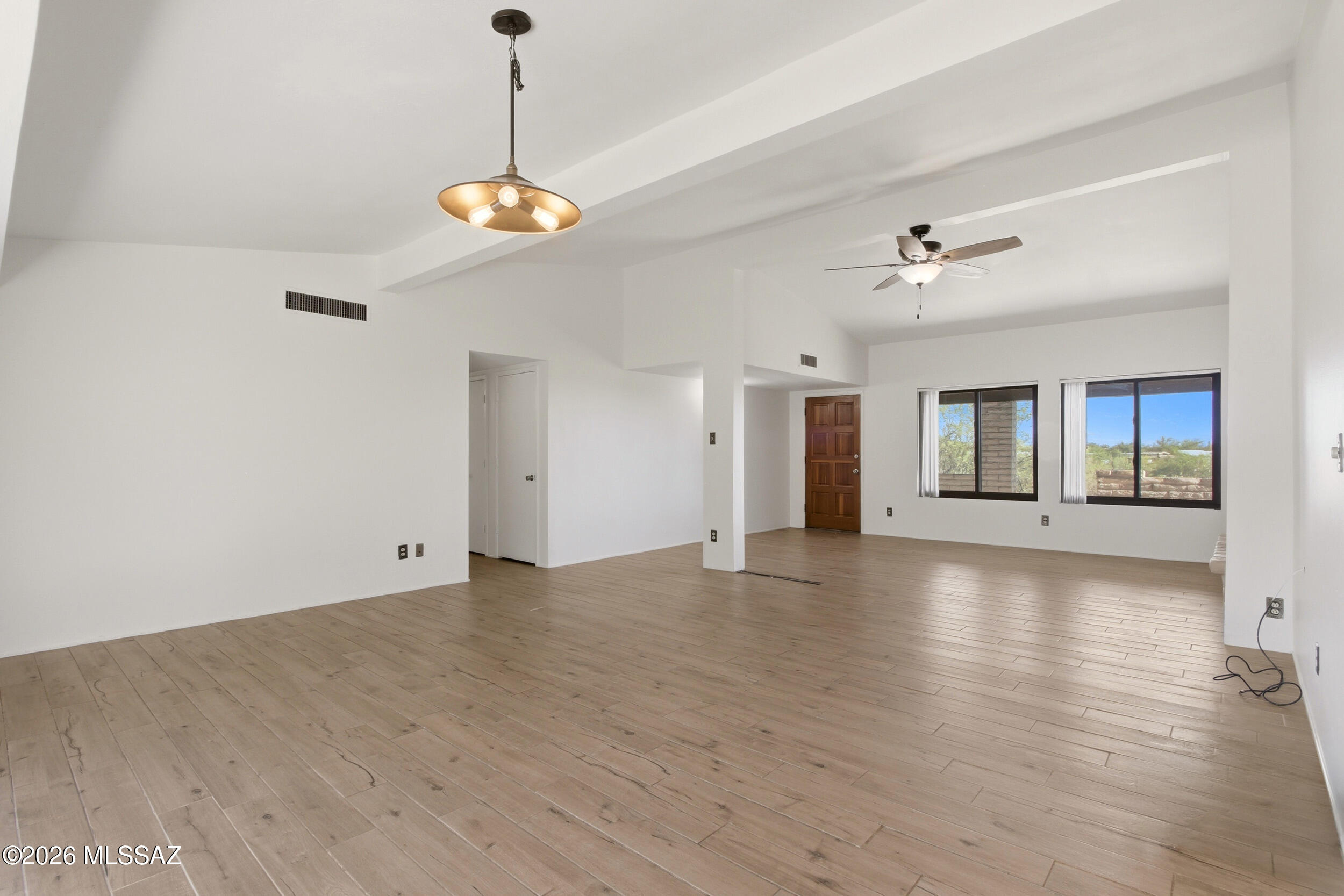 9141 East Indian Canyon Road Tucson, AZ 85749 - Photo 15 of 33 a view of an empty room with chandelier and wooden floor