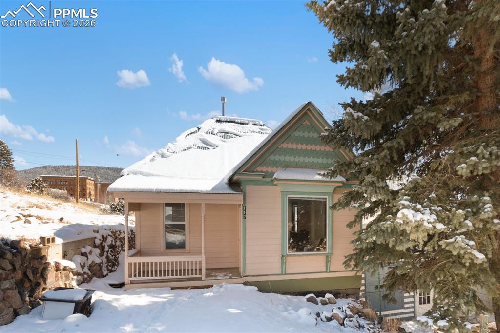 112 6th Street Victor, CO 80860 - Photo 1 of 35 a view of a white house with a large windows and a tree