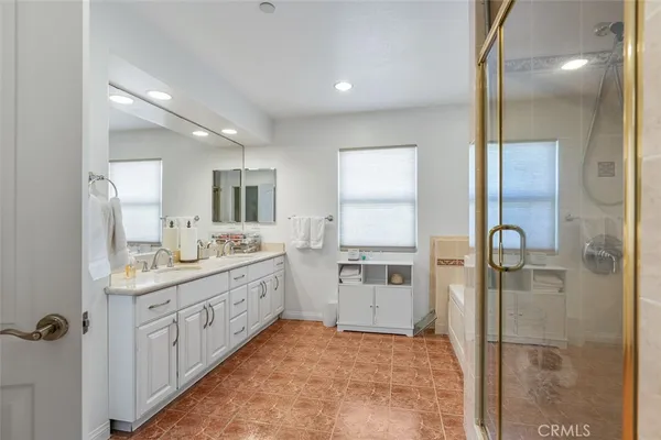 a bathroom with a double vanity sink mirror and shower
