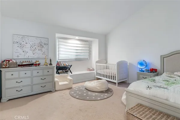a room with a baby bed and furniture