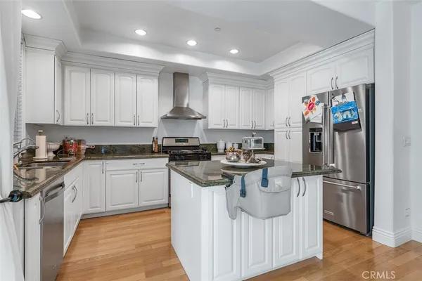 a kitchen with stainless steel appliances granite countertop a stove and a refrigerator