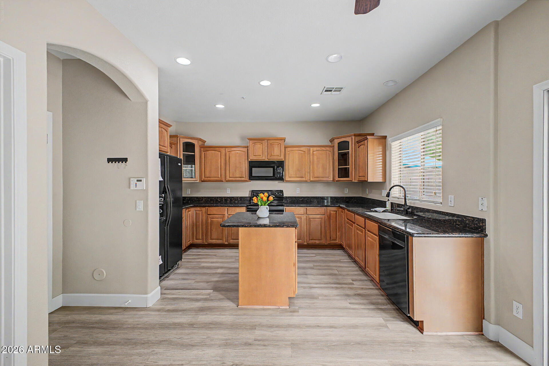 1379 East Joseph Way Gilbert, AZ 85295 - Photo 6 of 44 a large kitchen with stainless steel appliances granite countertop a stove top oven a sink dishwasher a refrigerator and cabinets with wooden floor