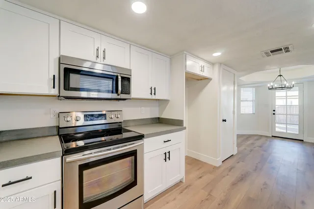 a kitchen with granite countertop white cabinets and a sink