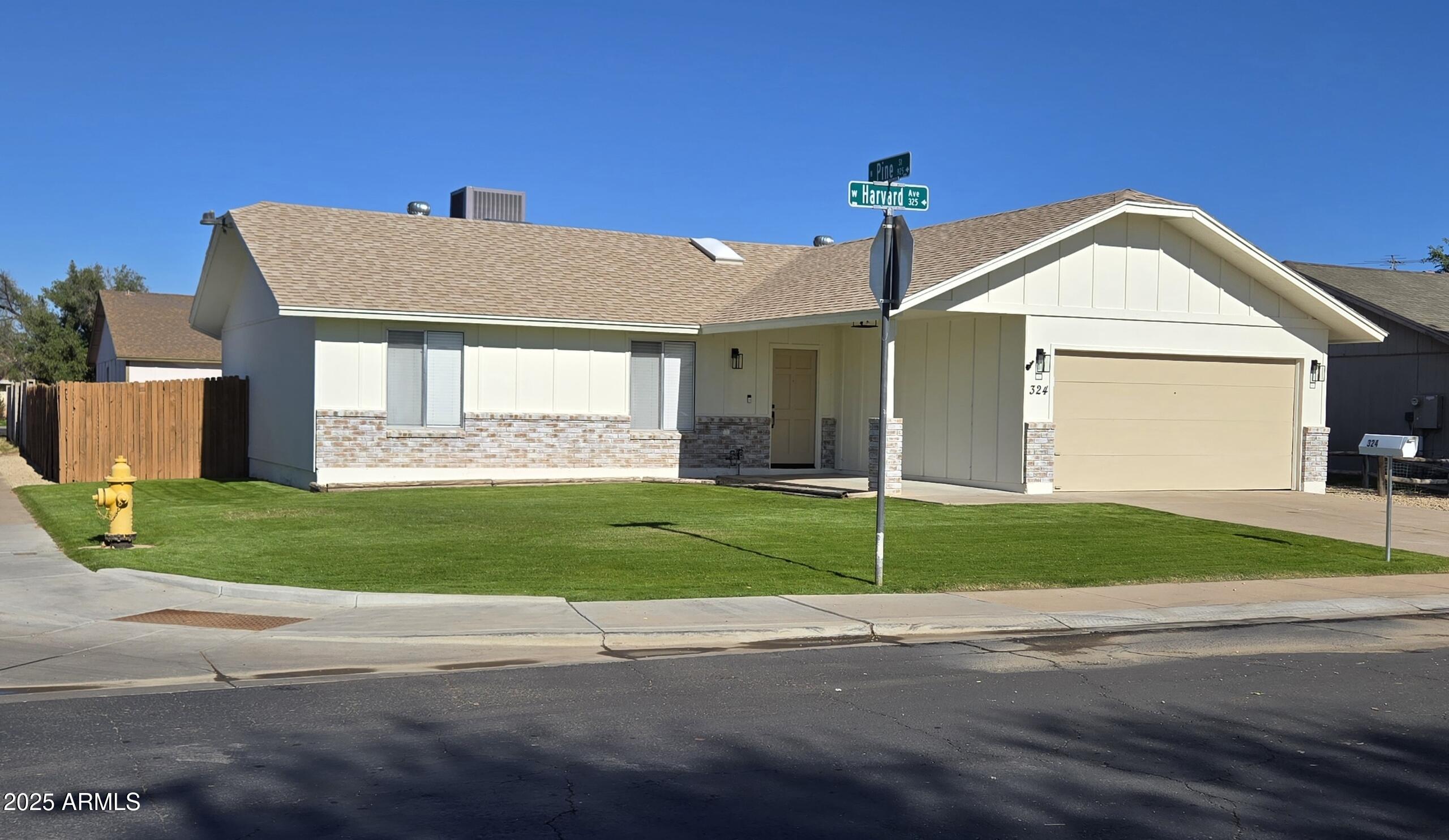 324 West Harvard Avenue Gilbert, AZ 85233 - Photo 2 of 27 a front view of a house with a garden and plants