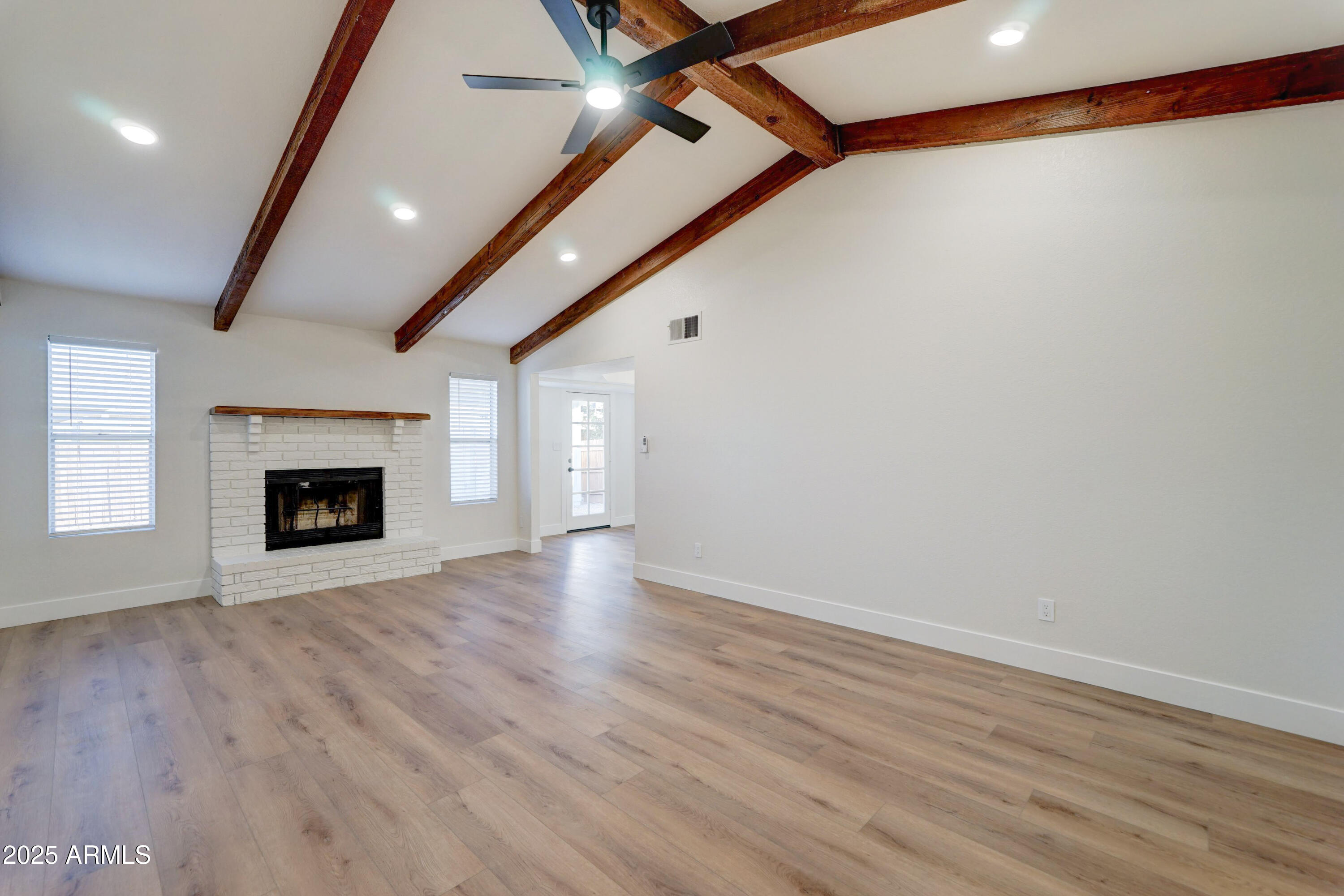 324 West Harvard Avenue Gilbert, AZ 85233 - Photo 4 of 27 an empty room with wooden floor and fireplace
