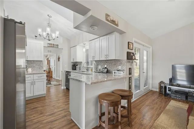 a kitchen with kitchen island white cabinets and stainless steel appliances