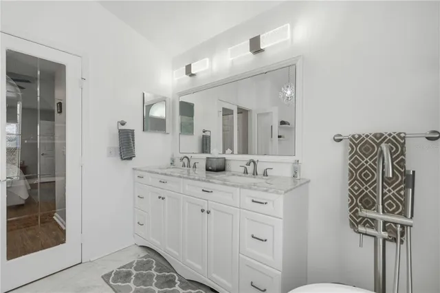 a spacious bathroom with a granite countertop sink and a mirror