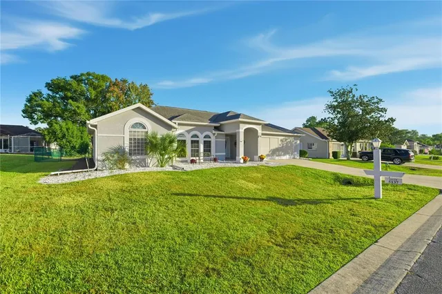 a view of house with a big yard and potted plants
