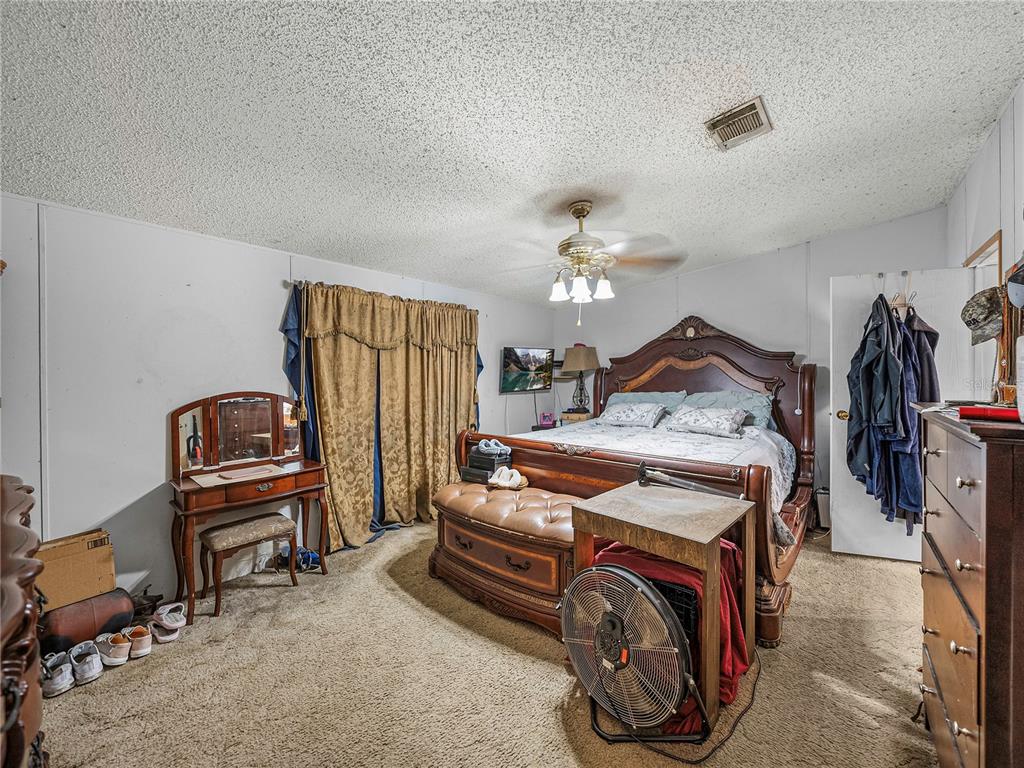 11404 Lithia Pinecrest Road Lithia, FL 33547 - Photo 30 of 63 a bedroom with a bed and a chandelier