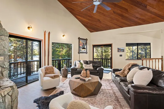a living room with furniture large window and wooden floor