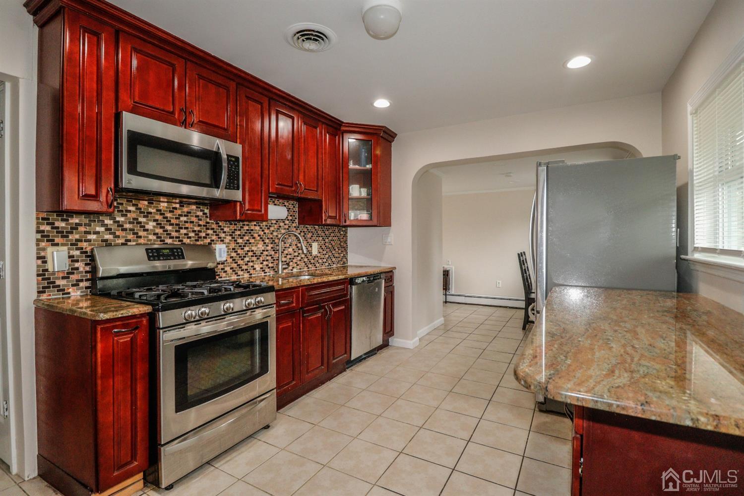 21 Kenmore Road Edison, NJ 08817 - Photo 5 of 23 a kitchen with stainless steel appliances granite countertop a stove microwave and refrigerator